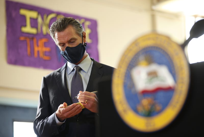 California Gov. Gavin Newsom takes notes before speaking at a news conference after meeting with students at James Denman Middle School on October 01, 2021 in San Francisco, California.