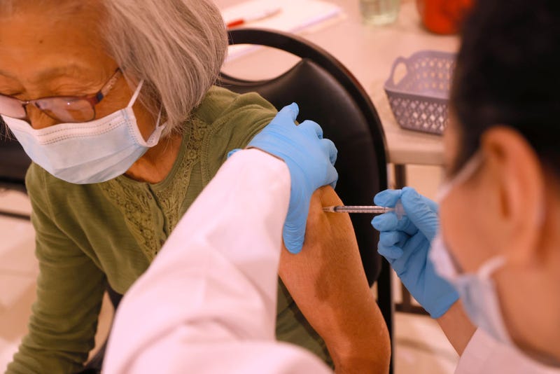 Safeway pharmacist Shahrzad Khoobyari (R) administers a Pfizer COVID-19 booster vaccination into the arm of Chen Knifsend at a vaccination booster shot clinic on October 01, 2021 in San Rafael, California.