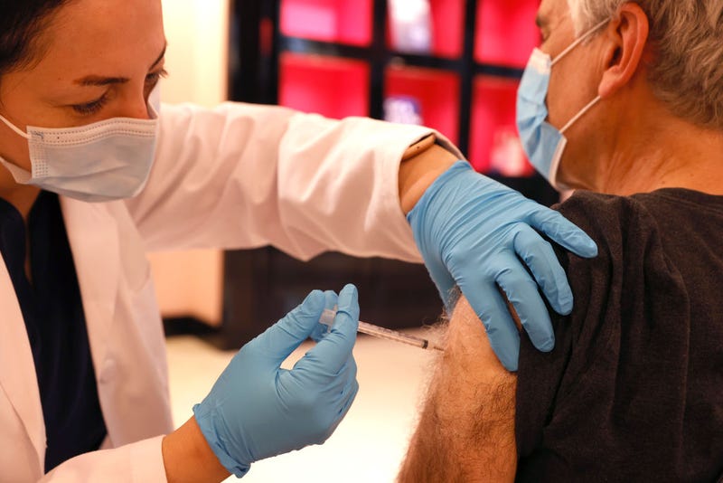 Safeway pharmacist Shahrzad Khoobyari (L) administers a Pfizer COVID-19 booster vaccination into the arm of Norman Solomon (R) at a vaccination booster shot clinic on October 01, 2021 in San Rafael, California.