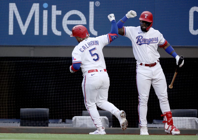 Willie Calhoun #5 of the Texas Rangers celebrates with Adolis Garcia #53 of the Texas Rangers after hitting a solo home run against the Cleveland Indians in the bottom of the first inning at Globe Life Field on October 02, 2021 in Arlington, Texas. 