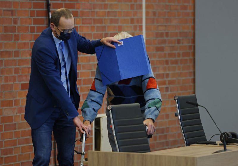 A 100-year-old man accused of being a former Nazi-era concentration camp guard is assisted by his lawyer as he arrives for the first day of his trial in accessory to the murder of 3,500 people on October 07, 2021 in Brandenburg, Germany. The man is accused of having worked as a guard at the Sachsenhausen concentration camp near Berlin from 1942 to 1945 during World War II, where prisoners, including Jews, captured Soviet soldiers and political dissidents, were systematically mistreated and murdered. (Photo by Sean Gallup/Getty Images)