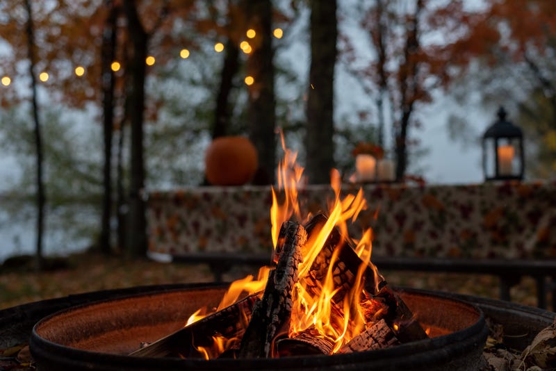 Glowing campfire at autumn campsite - stock photo