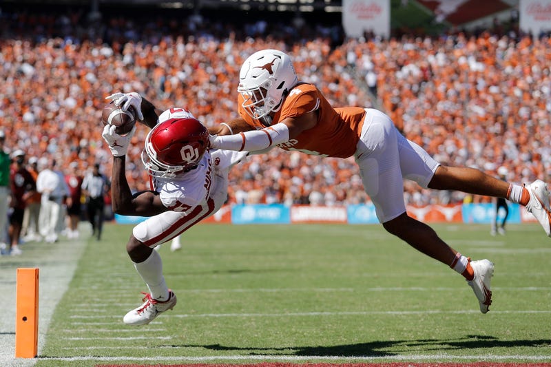 Marvin Mims #17 of the Oklahoma Sooners catches a pass for a touchdown while defended by Darion Dunn #4 of the Texas Longhorns in the fourth quarter during the 2021 AT&T Red River Showdown at Cotton Bowl on Oct. 9, 2021 in Dallas, Texas.