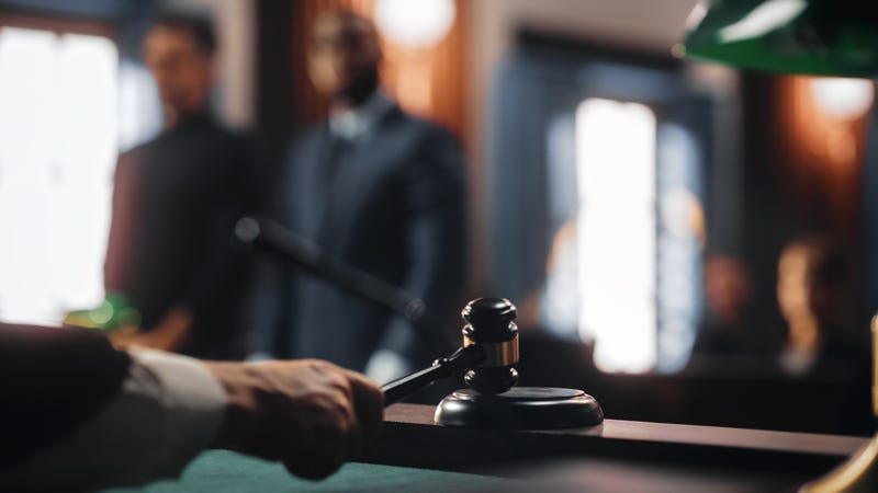 Two men in a court room while a judge delivers sentencing.