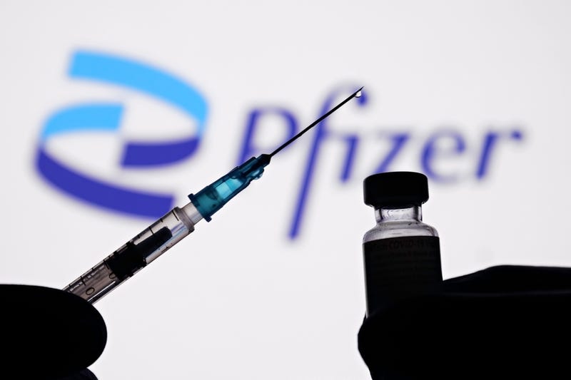 In this photo illustration, a medical syringe and vials of the Pfizer US pharmaceutical corporation and BioNTech German biotechnology 2021 company logos are seen on October 03, 2021 in New York City. 