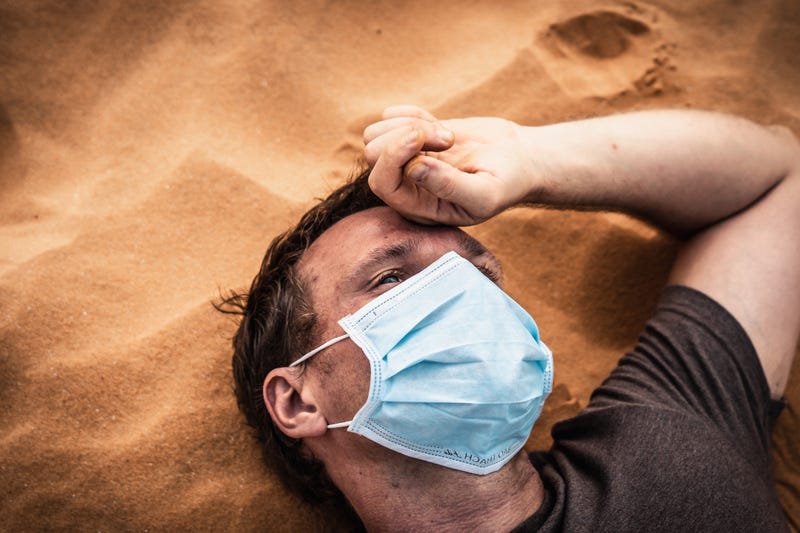 Side portrait man wear protective mask, face expression emotion lies on back, hand on forehead. 