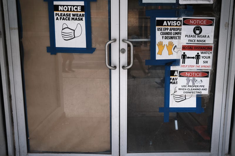 Signs on a door warn people about COVID-19 in Manhattan