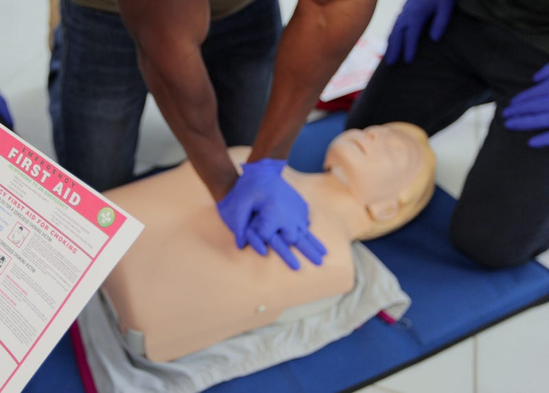 Person practicing CPR on a dummy