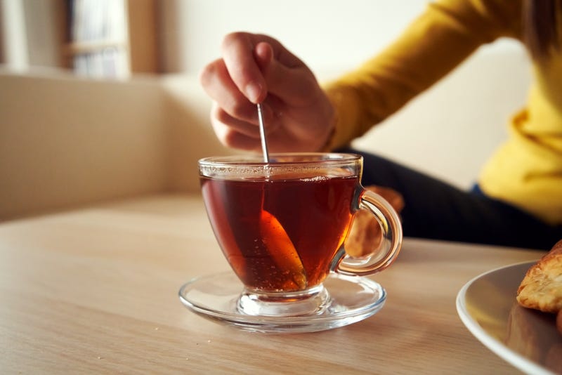 Woman's hand stirring tea.
