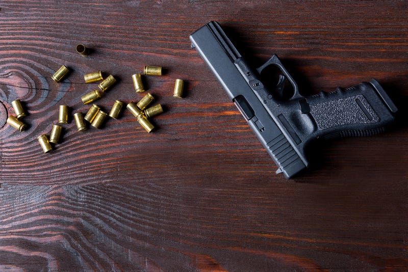 Hand gun and empty bullet casings.  