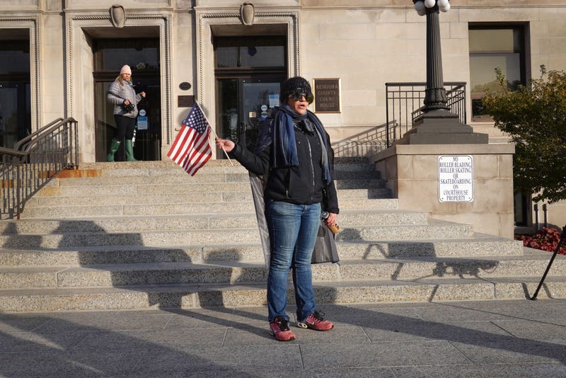 A woman who identified herself as a "patriot" demonstrates outside the Kenosha County Courthouse as jury selection in the trial of Kyle Rittenhouse begins on November 01, 2021 in Kenosha, Wisconsin. Rittenhouse shot three demonstrators, killing two of them, during a night of unrest that erupted in Kenosha after a police officer shot Jacob Blake seven times in the back while police attempted to arrest him in August 2020. Rittenhouse, from Antioch, Illinois, was 17 at the time of the shooting and armed with an assault rifle. He faces counts of felony homicide and felony attempted homicide.