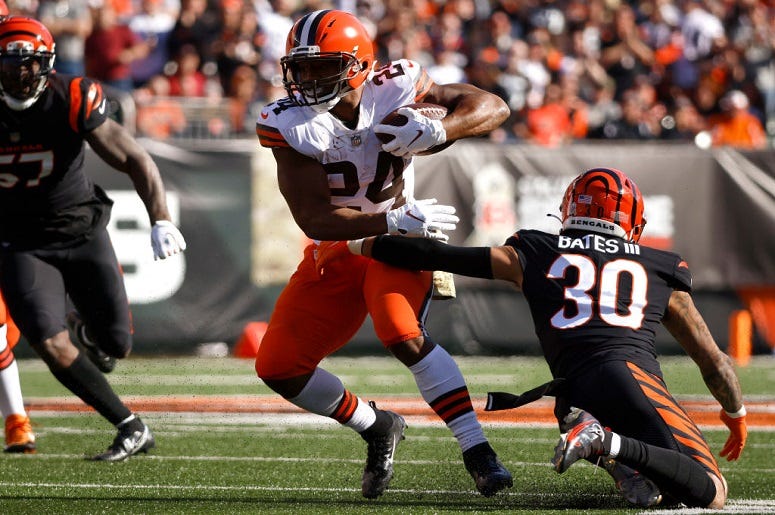 Nick Chubb runs the ball and avoids a tackle by Jessie Bates