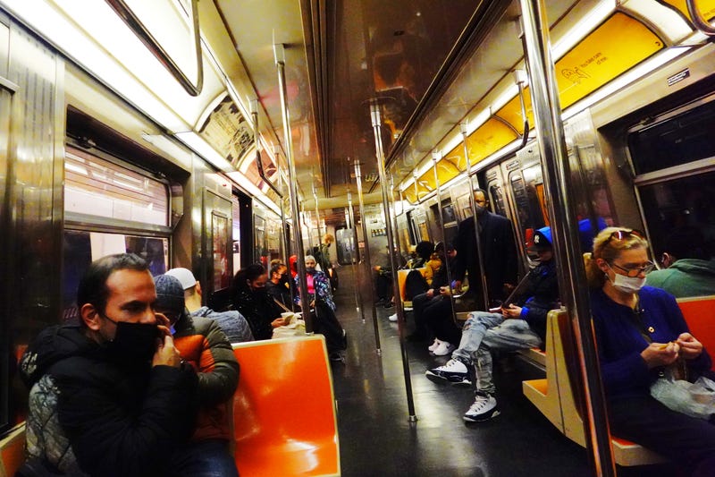 People ride a Q train in New York City