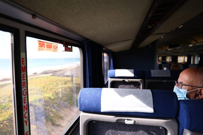 A passenger rides an Amtrak train passing near the Pacific Ocean on November 9, 2021 near Oceanside, California.