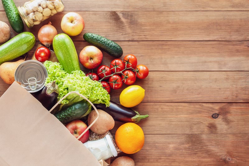 vegetables and paper shopping bag on wooden table