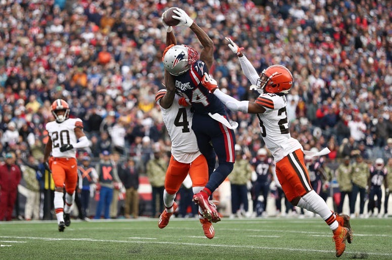 Kendrick Bourne of the New England Patriots completes a touchdown pass against Troy Hill of the Cleveland Browns