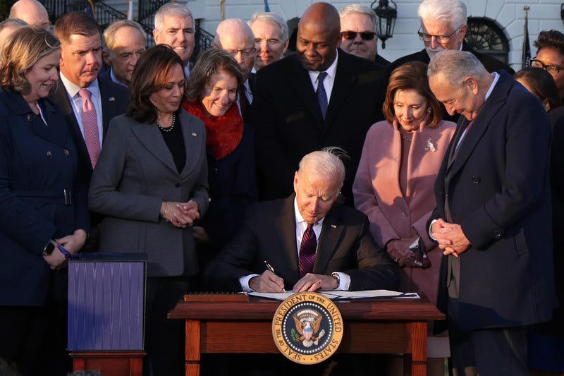 President Joe Biden signs the Infrastructure Investment and Jobs Act as he is surrounded by lawmakers and members of his Cabinet during a ceremony on the South Lawn at the White House on November 15, 2021 in Washington, DC.