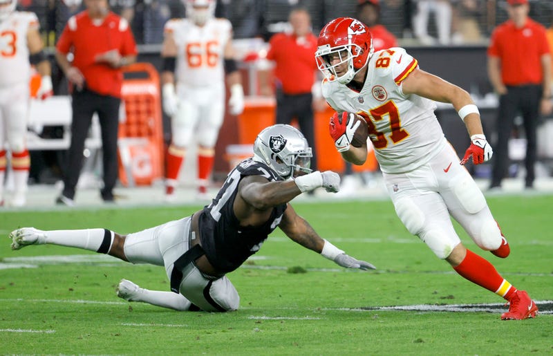 Tight end Travis Kelce #87 of the Kansas City Chiefs avoids a tackle by defensive tackle Quinton Jefferson #77 of the Las Vegas Raiders during their game at Allegiant Stadium