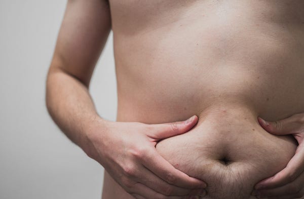 Chubby man holding his belly