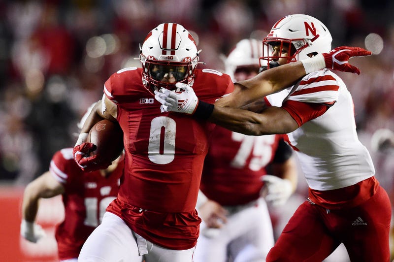 Braelon Allen #0 of the Wisconsin Badgers breaks the tackle of Myles Farmer #4 of the Nebraska Cornhuskers and scores a 53-yard touchdown in the fourth quarter at Camp Randall Stadium on November 20, 2021 in Madison, Wisconsin.