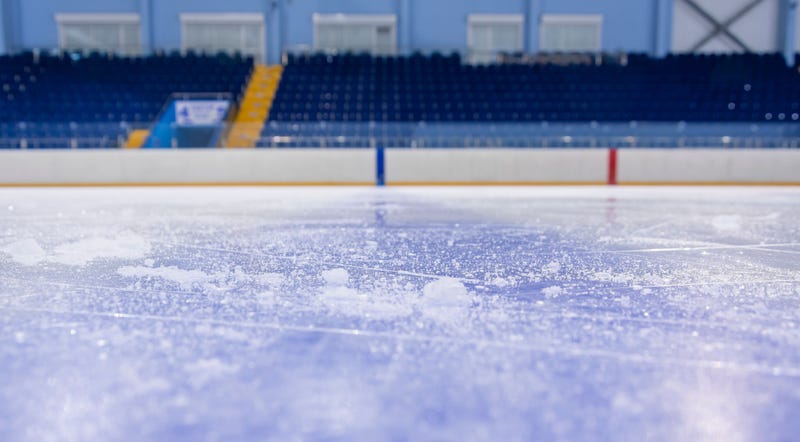 A girls high school hockey coach is in critical condition after hitting his head on the ice in a freak accident.