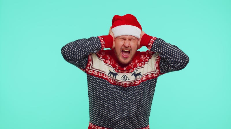 Man in holiday apparel covering his ears