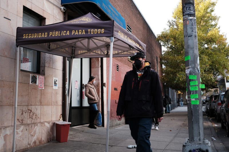 People walk past an East Harlem health clinic that offers free needles and other services to drug users on Dec. 1, 2021
