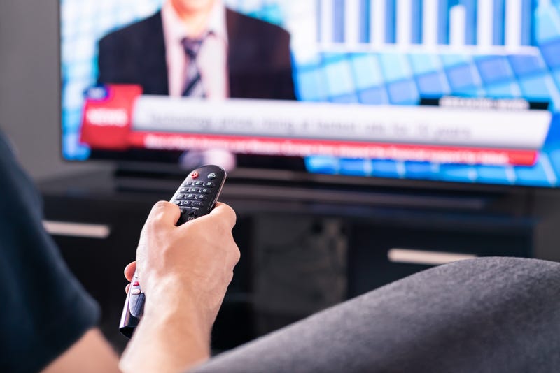 Breaking news on tv. Man watching live television broadcast program. Covid19, coronavirus and medical information or election reporter and presenter in world politics. - stock photo