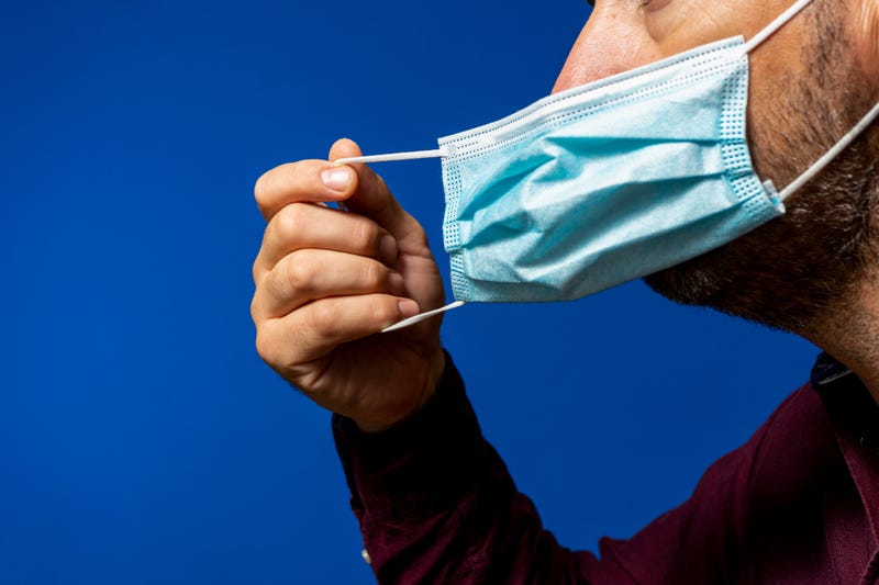 Man takes off mask.