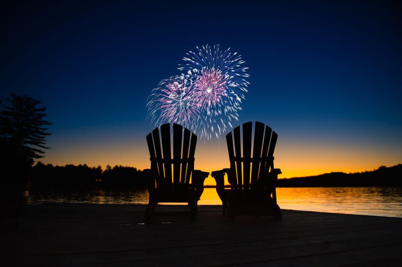 Fireworks and lawn chairs near lake