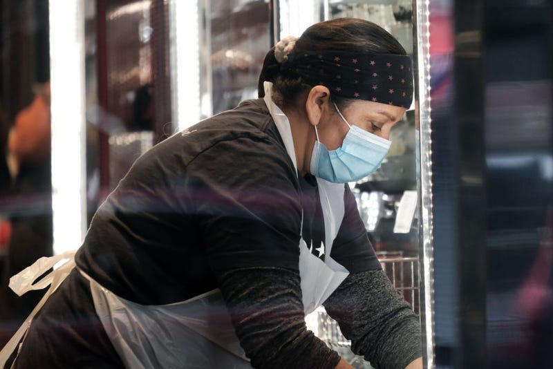 Workers at a restaurant wear masks in lower Manhattan on the day that a mask mandate went into effect in New York on December 13, 2021 in New York City.
