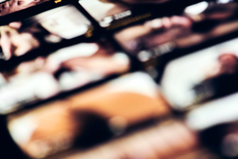 Watching porn on mobile phone, blurred image of mobile phone with porn scene