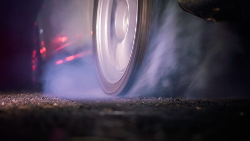 drag racing car burning tire at starting line