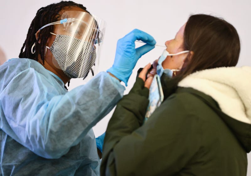 Merline Jimenez (L) administers a COVID-19 nasopharyngeal swab to a person at a testing site located in the international terminal at Los Angeles International Airport (LAX) amid a surge in omicron variant cases on December 21, 2021 in Los Angeles, California.