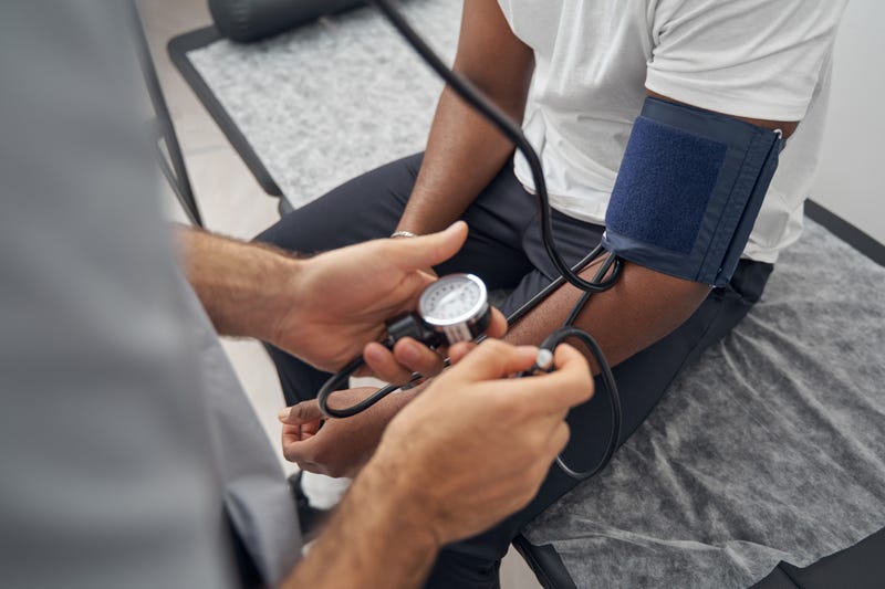 Doctor taking an African American patient's blood pressure.