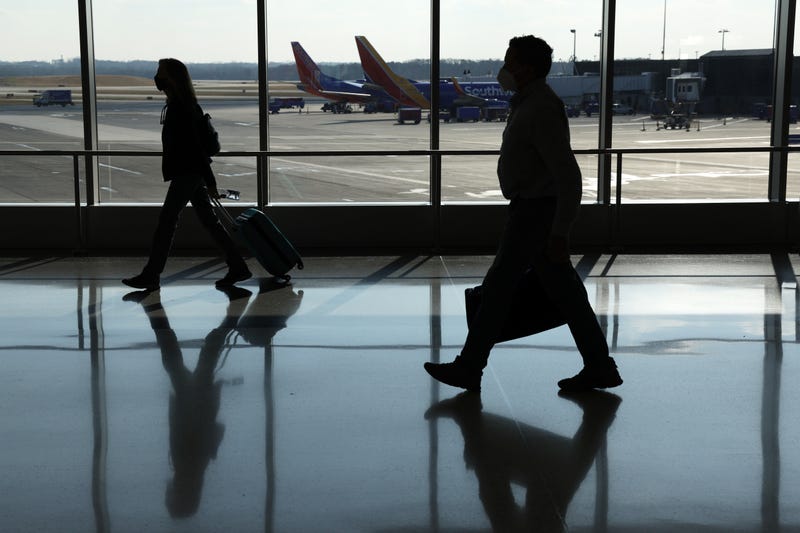 Passengers walk through a terminal at Baltimore/Washington International Thurgood Marshall Airport (BWI) on December 22, 2021 in Baltimore, Maryland.