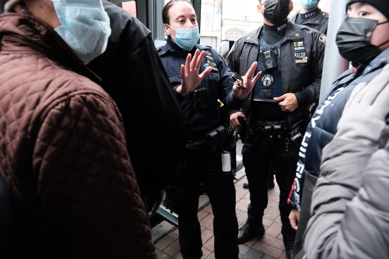 People form a large crowd as they attempt to receive COVID-19 testing kits from city workers distributing the kits along Flatbush Avenue in Brooklyn on Dec. 24, 2021