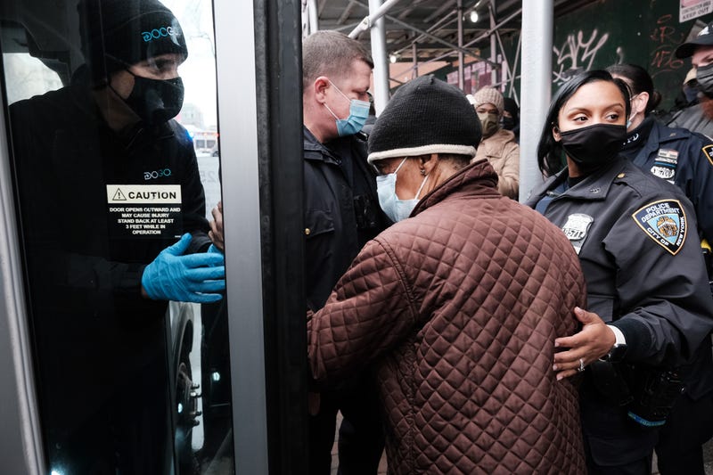 People form a large crowd as they attempt to receive COVID-19 testing kits from city workers distributing the kits along Flatbush Avenue in Brooklyn on Dec. 24, 2021