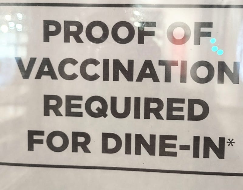 A sign at a restaurant requiring COVID-19 vaccination proof.