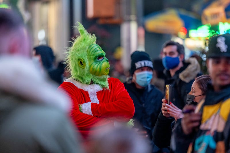 A street performer dressed as Dr. Seuss' the Grinch takes photos with tourists in Times Square on December 25, 2021 in New York City.