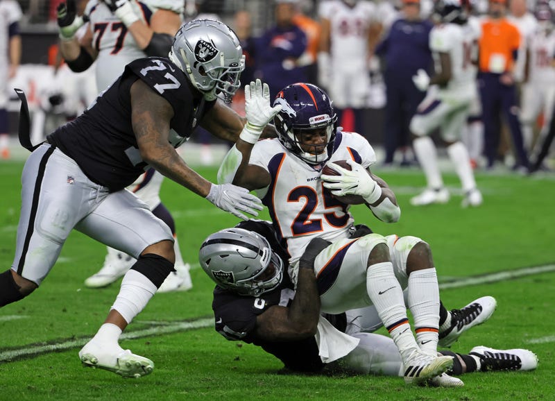 Defensive end Yannick Ngakoue #91 of the Las Vegas Raiders tackles running back Melvin Gordon III #25 of the Denver Broncos for a 4-yard loss