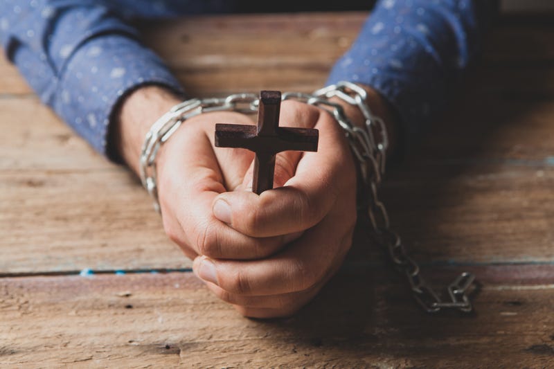 prisoner in chains praying powers cross