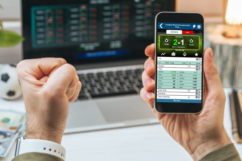 person checking sports betting website on phone