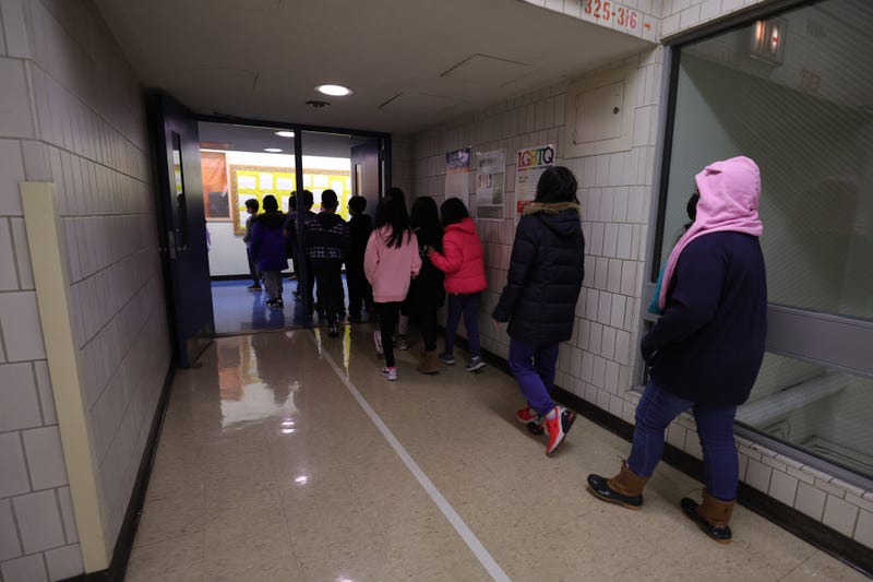 Masked students walk to their classroom at a public school in Lower Manhattan