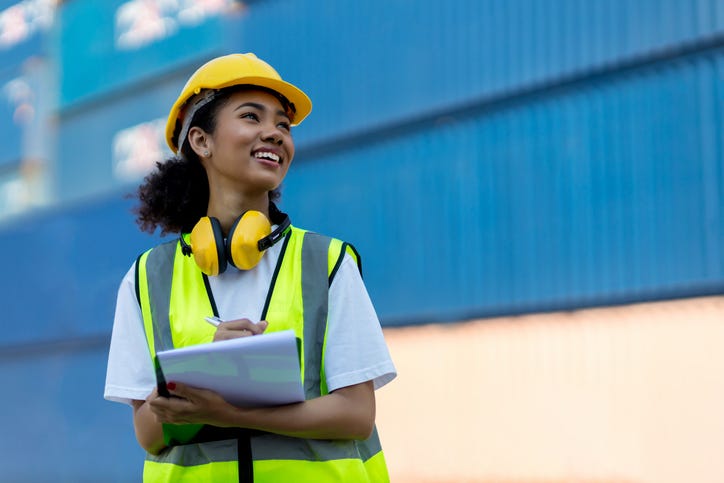 Female Foreman or worker hand holding checklist for writing and checking in goods in container at Container cargo site