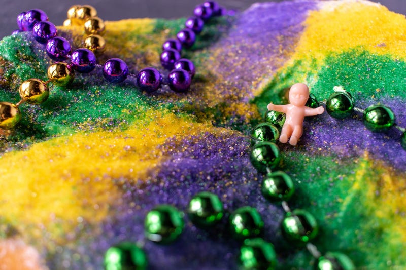 closeup King cake with Mardi Gras beads and baby
