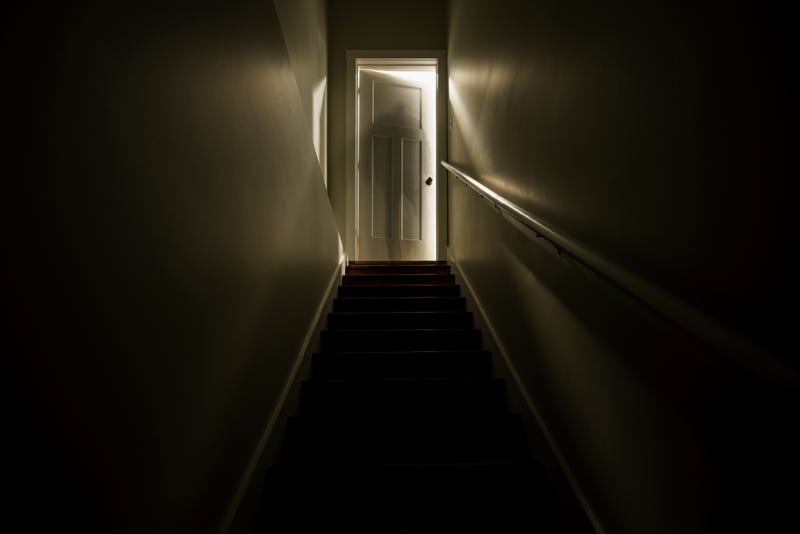 Dark staircase to an open door. 