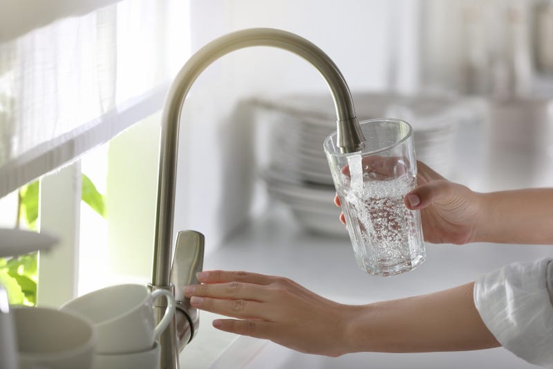 Person filling a glass of water