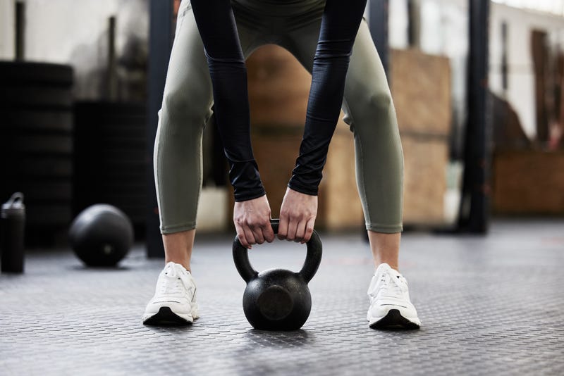 Person lifting a kettle bell to workout. 