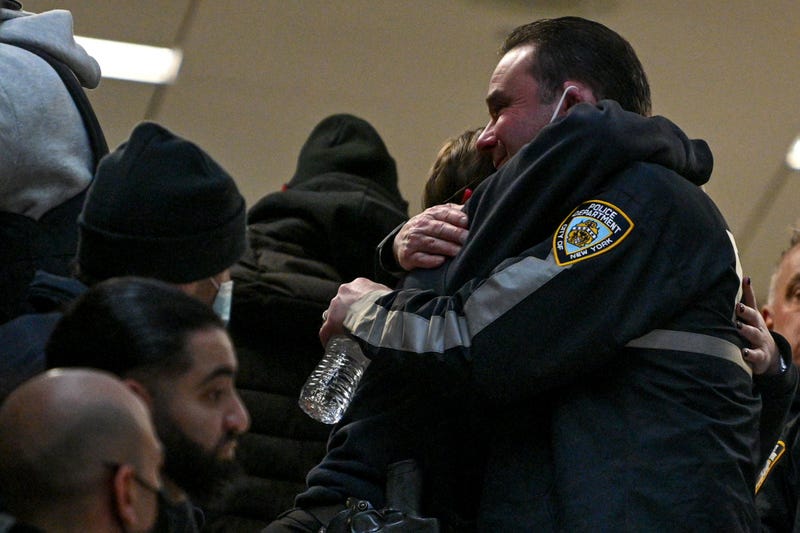 NYPD officers embrace at Harlem Hospital on January 21, 2022 in New York City. One officer was killed and the other remains in critical condition at Harlem Hospital.